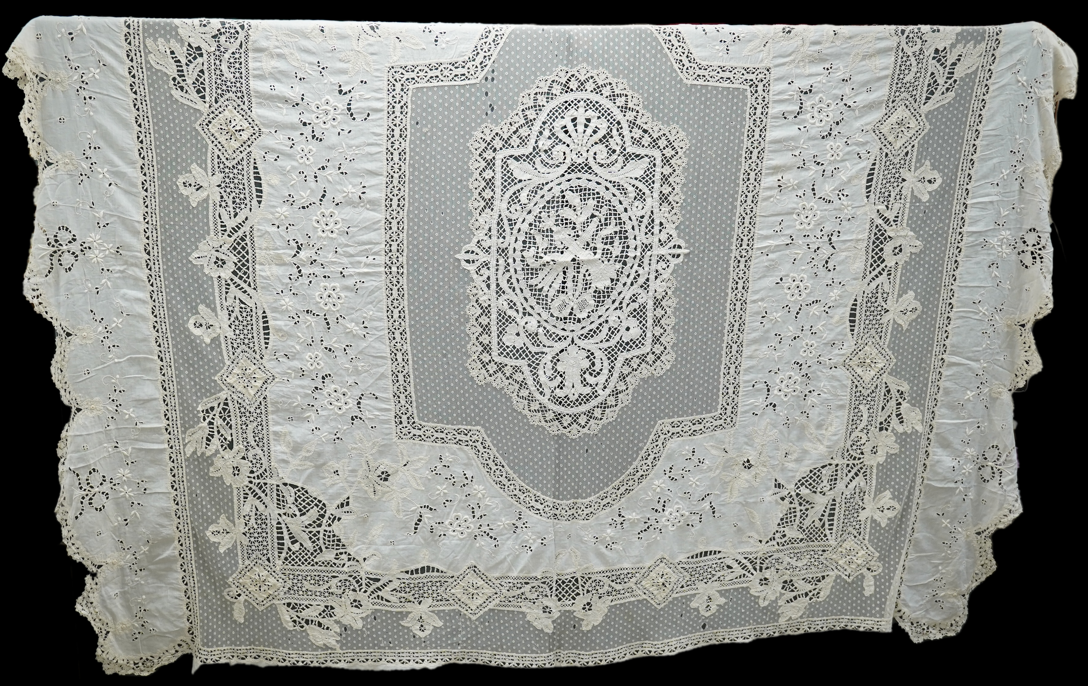 An ornate Edwardian bed cover, handmade from cut work anglaise panels, fine spot motif net and bobbin lace insertions, 228cm wide x 228 cm long. Condition - the spot motif net and fine lawn are damaged in places, the law